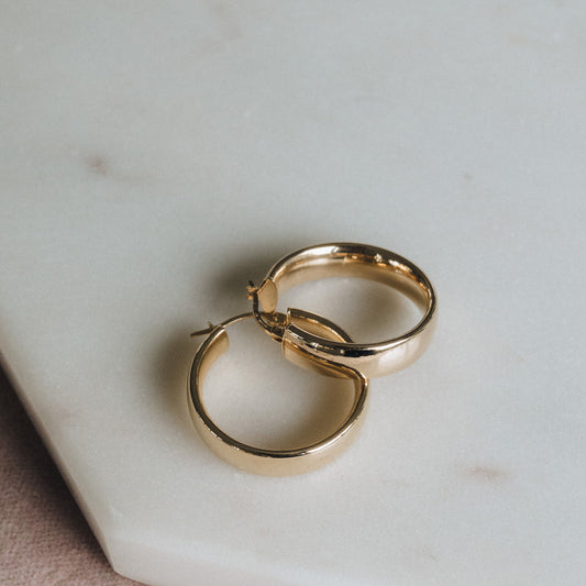 Small 9ct gold D-shape hoops displayed together on white background