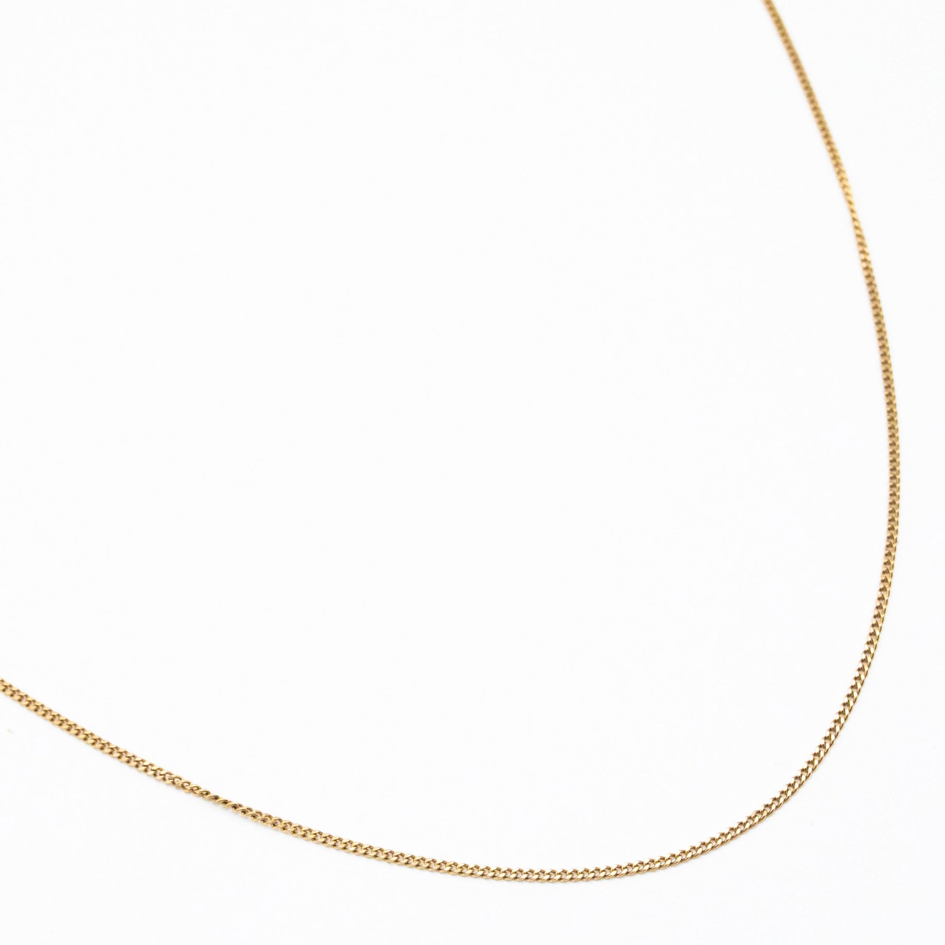 1.2mm curb link chain in 9ct yellow gold flatlay with white background