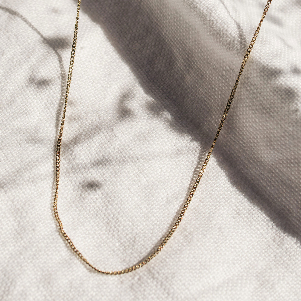 1.2mm curb link chain in 9ct yellow gold flatlay