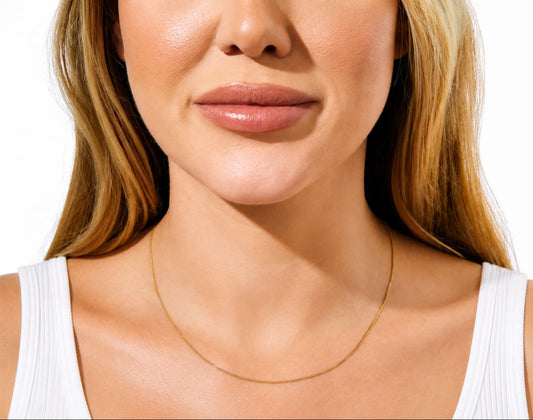 1.2mm curb link chain in 9ct yellow gold worn around the neck
