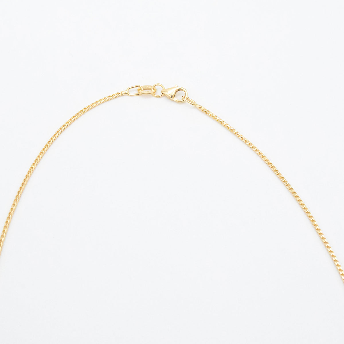 1.1mm Franco chain necklace in 9ct yellow gold laid flat on a white background with clasp visible