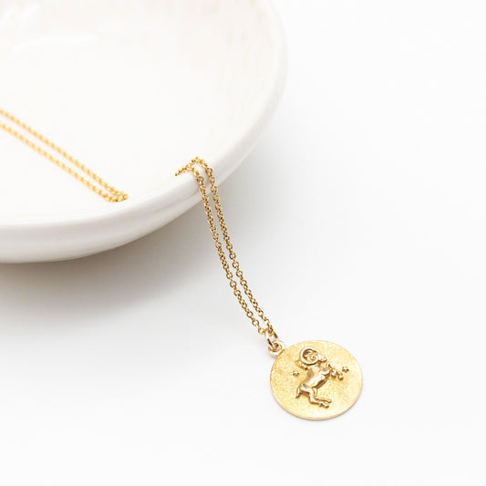9ct yellow gold zodiac pendant necklace featuring a round 12mm medallion with a polished astrological symbol and textured matte background.