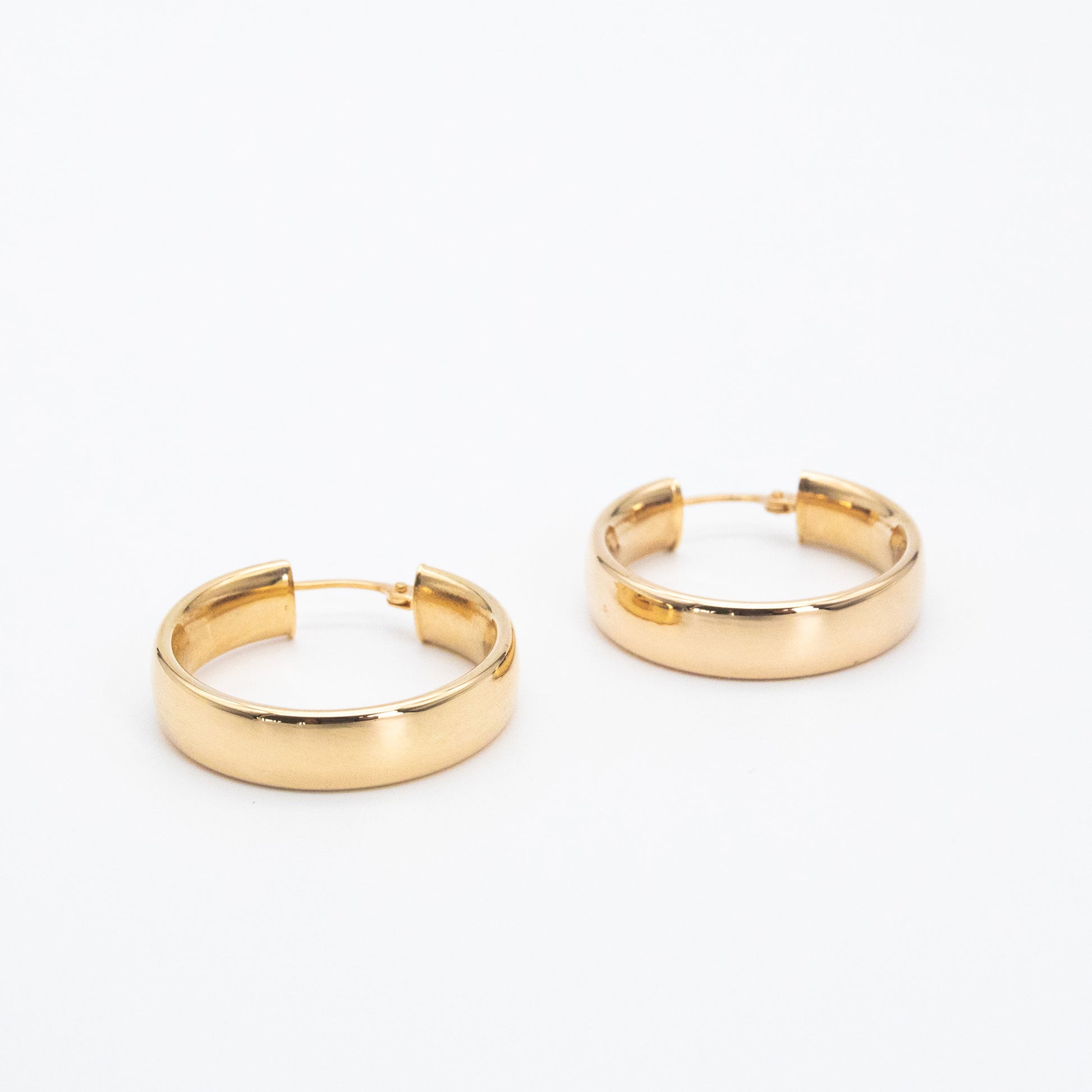 Small 9ct gold D-shape hoops displayed together on white background