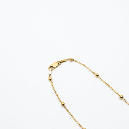 9ct yellow gold dotted chain necklace with evenly spaced gold beads, laid flat on a white background showing clasp