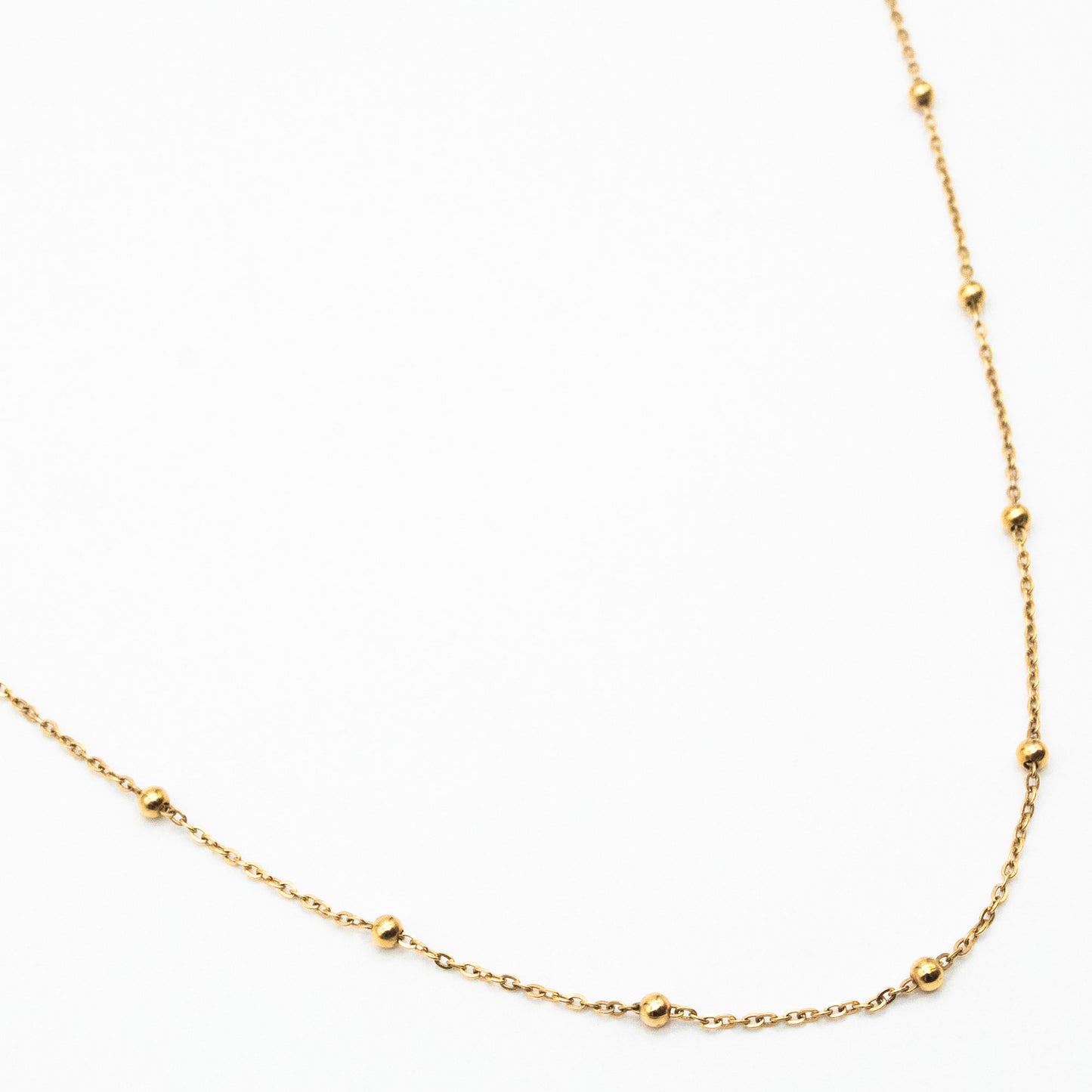 9ct yellow gold dotted chain necklace with evenly spaced gold beads, laid flat on a white background