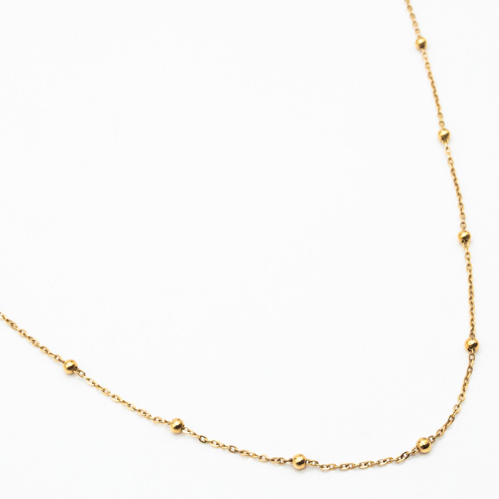 9ct yellow gold dotted chain necklace with evenly spaced gold beads, laid flat on a white background