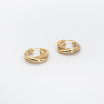 Double tube twisted hollow gold hoop earrings on white background.