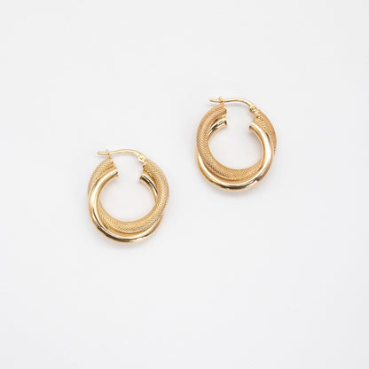 Double tube twisted hollow gold hoop earrings on white background.
