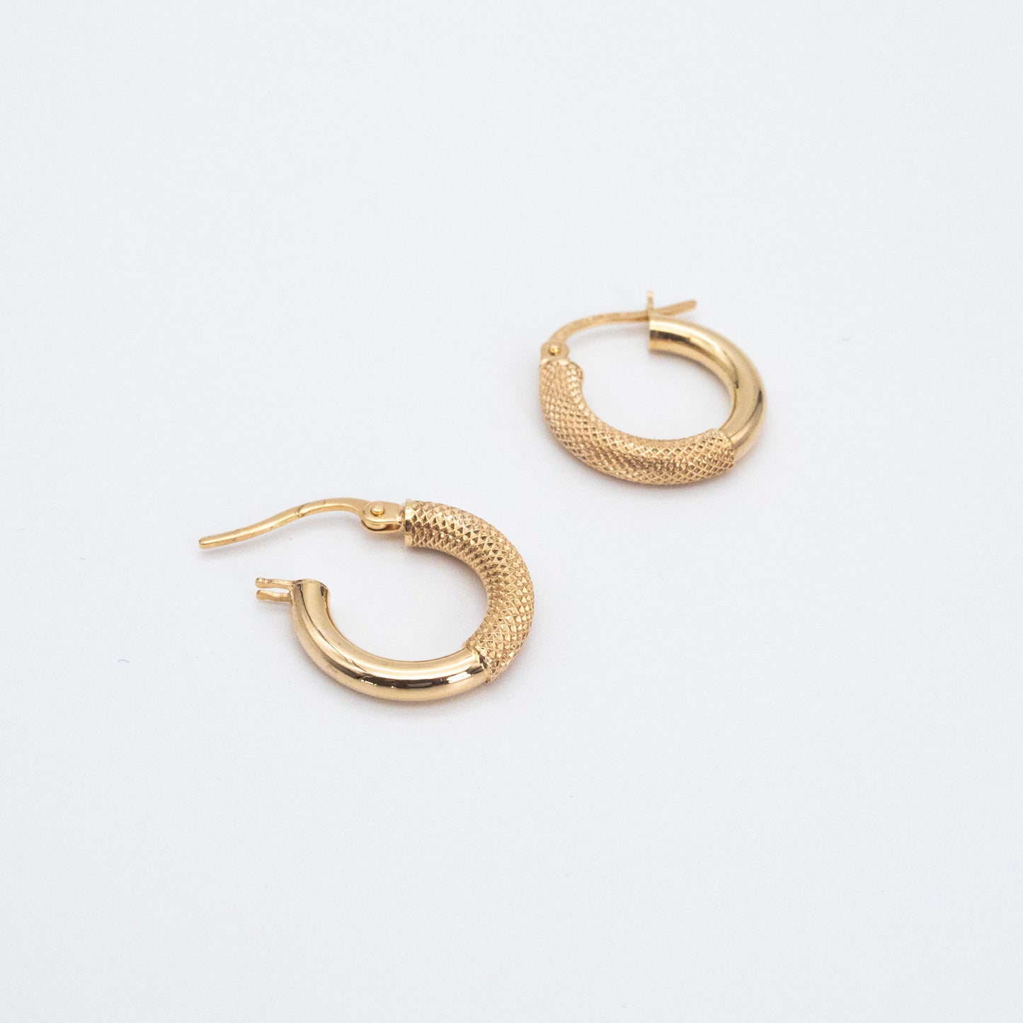 Pair of fancy gold hoops shown flat on a white backdrop