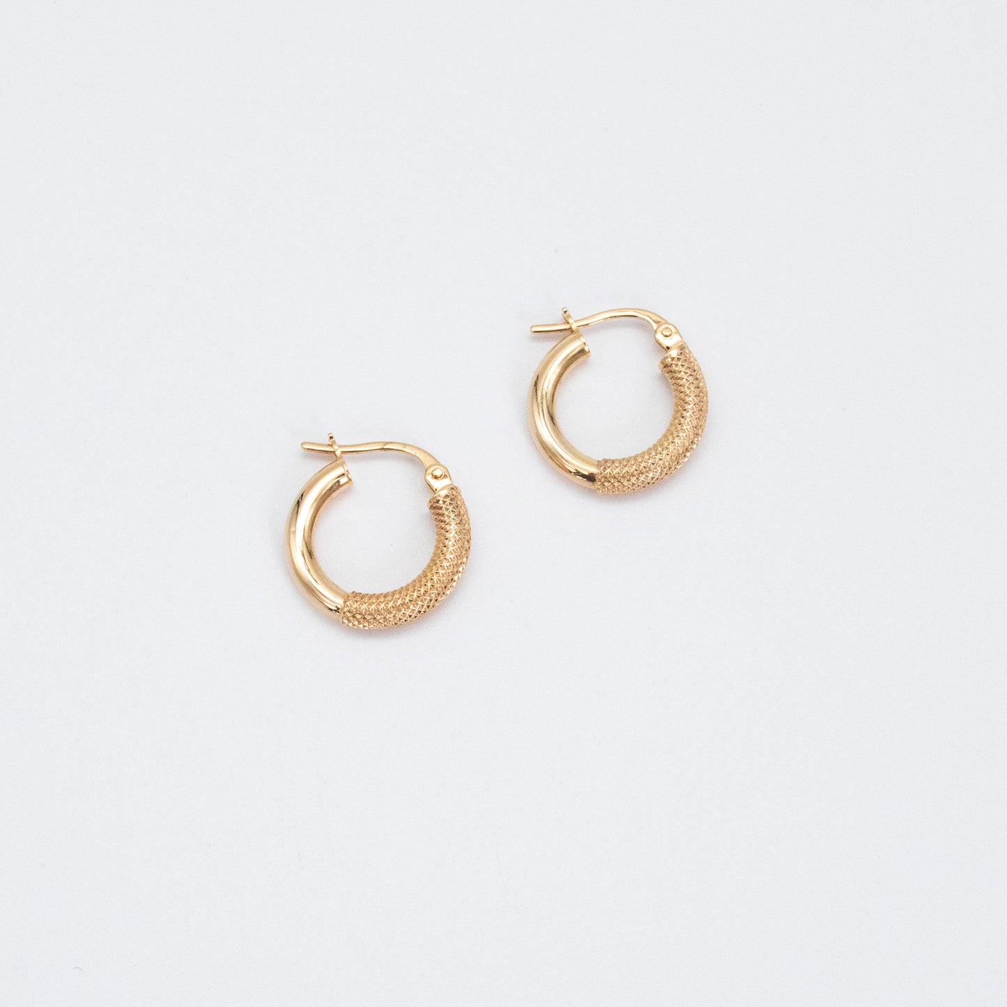 Pair of fancy gold hoops shown flat on a white backdrop
