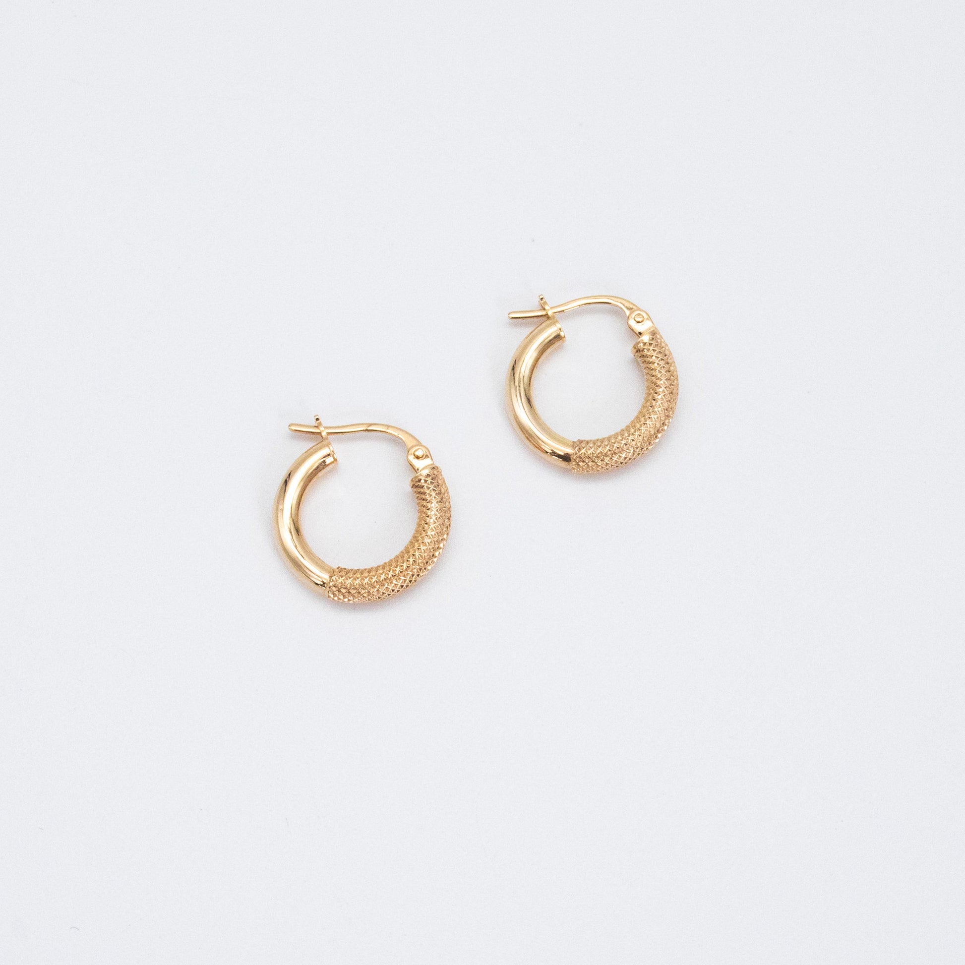 Pair of fancy gold hoops shown flat on a white backdrop