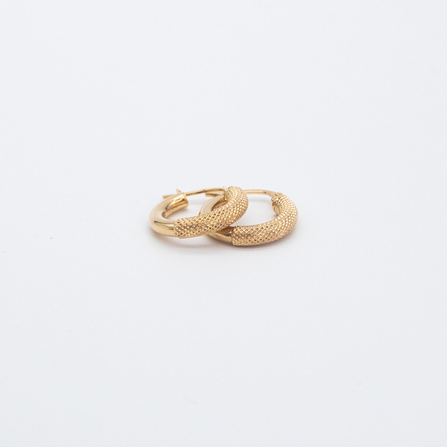 Pair of fancy gold hoops shown flat on a white backdrop