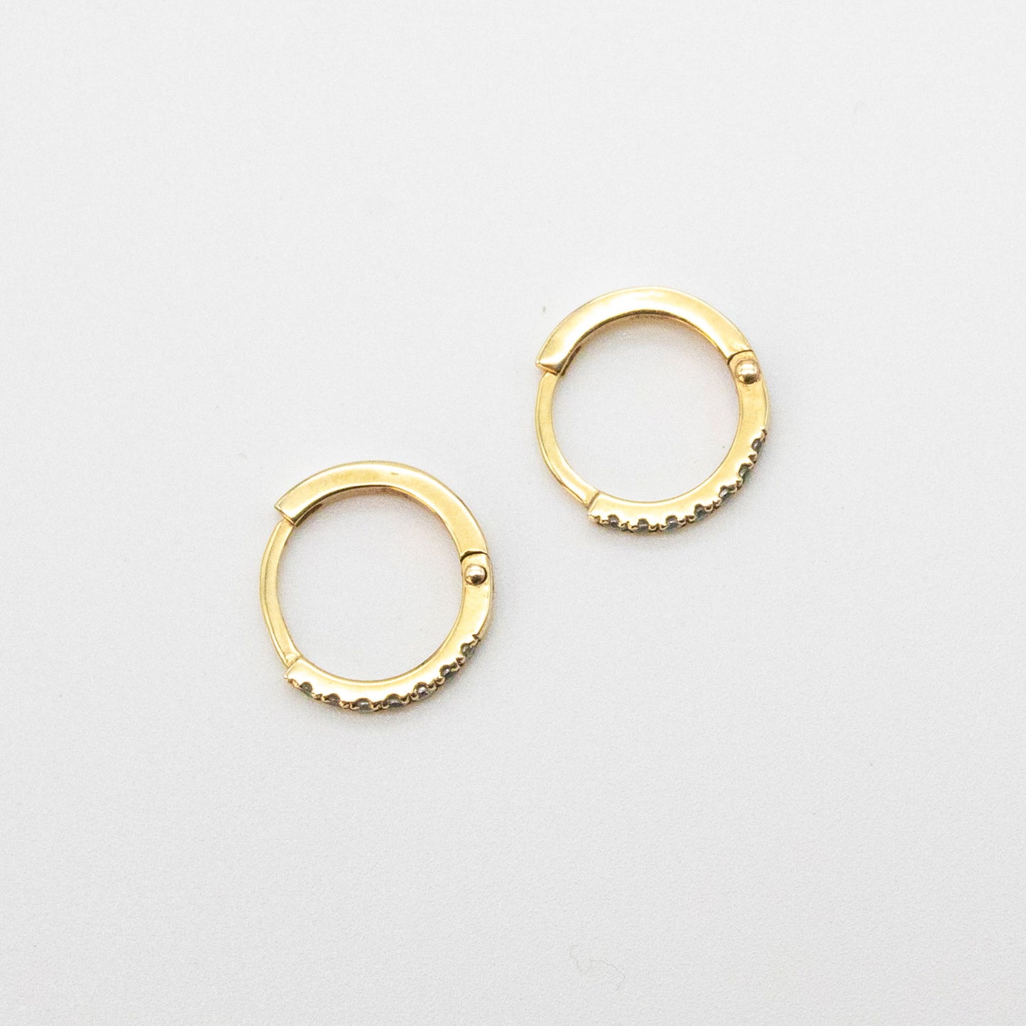 Mini Diamond Huggies 12mm displayed on a white background, showcasing seven round diamonds set in 9ct gold.