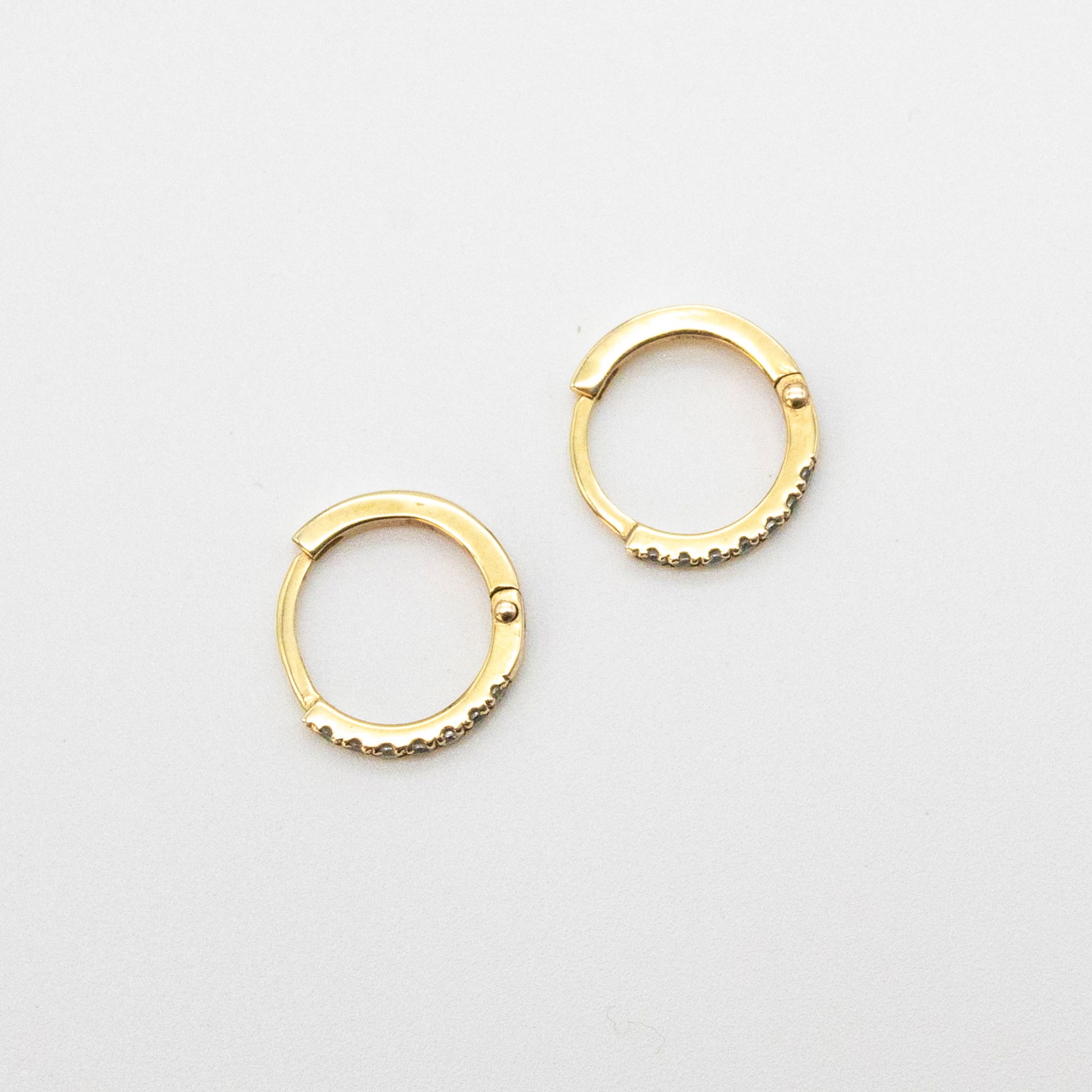 Mini Diamond Huggies 12mm displayed on a white background, showcasing seven round diamonds set in 9ct gold.