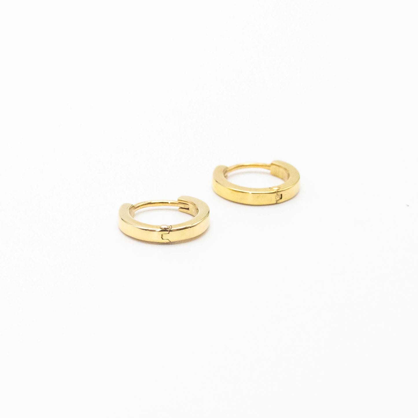 Single pair of mini gold huggies photographed on white background