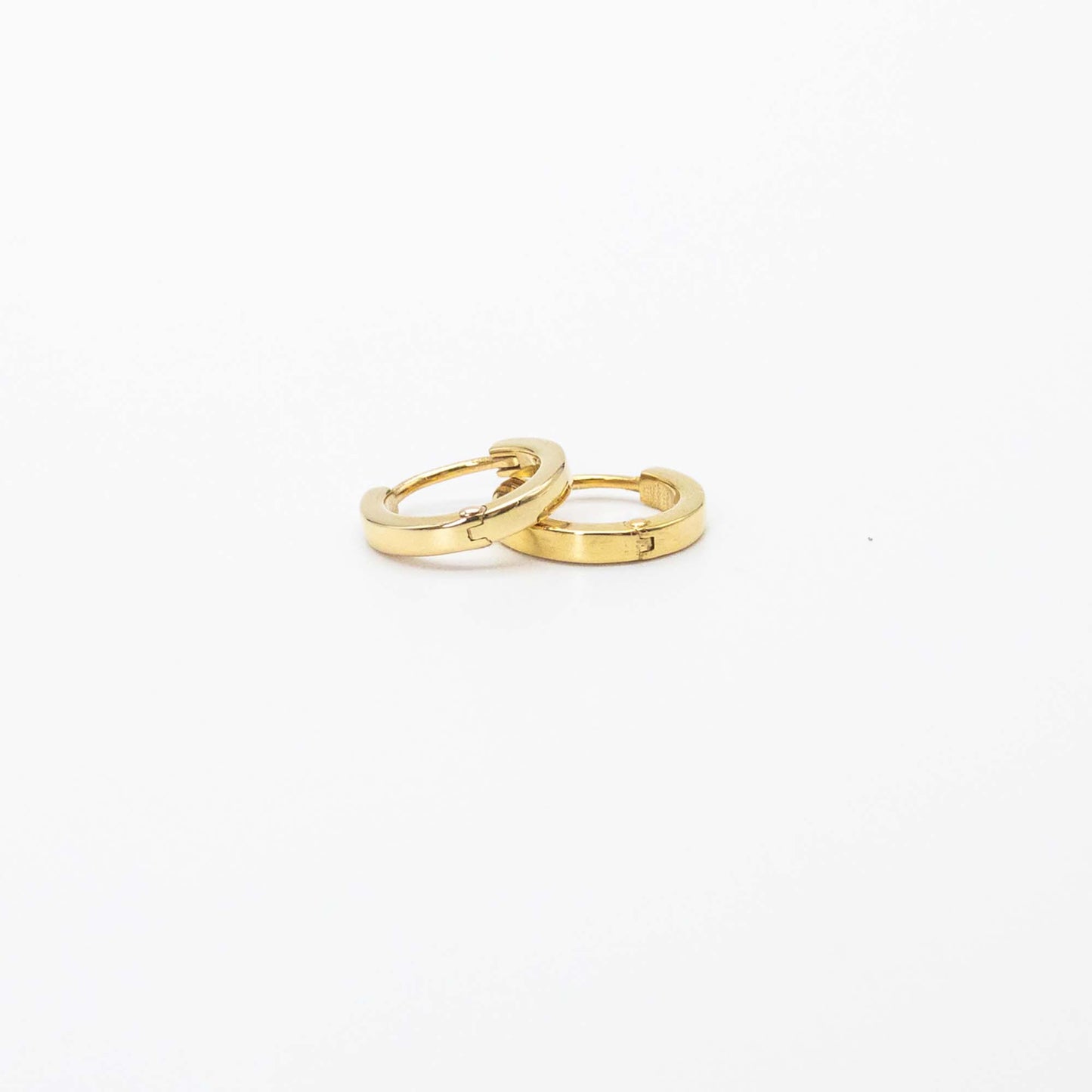 Single pair of mini gold huggies photographed on white background