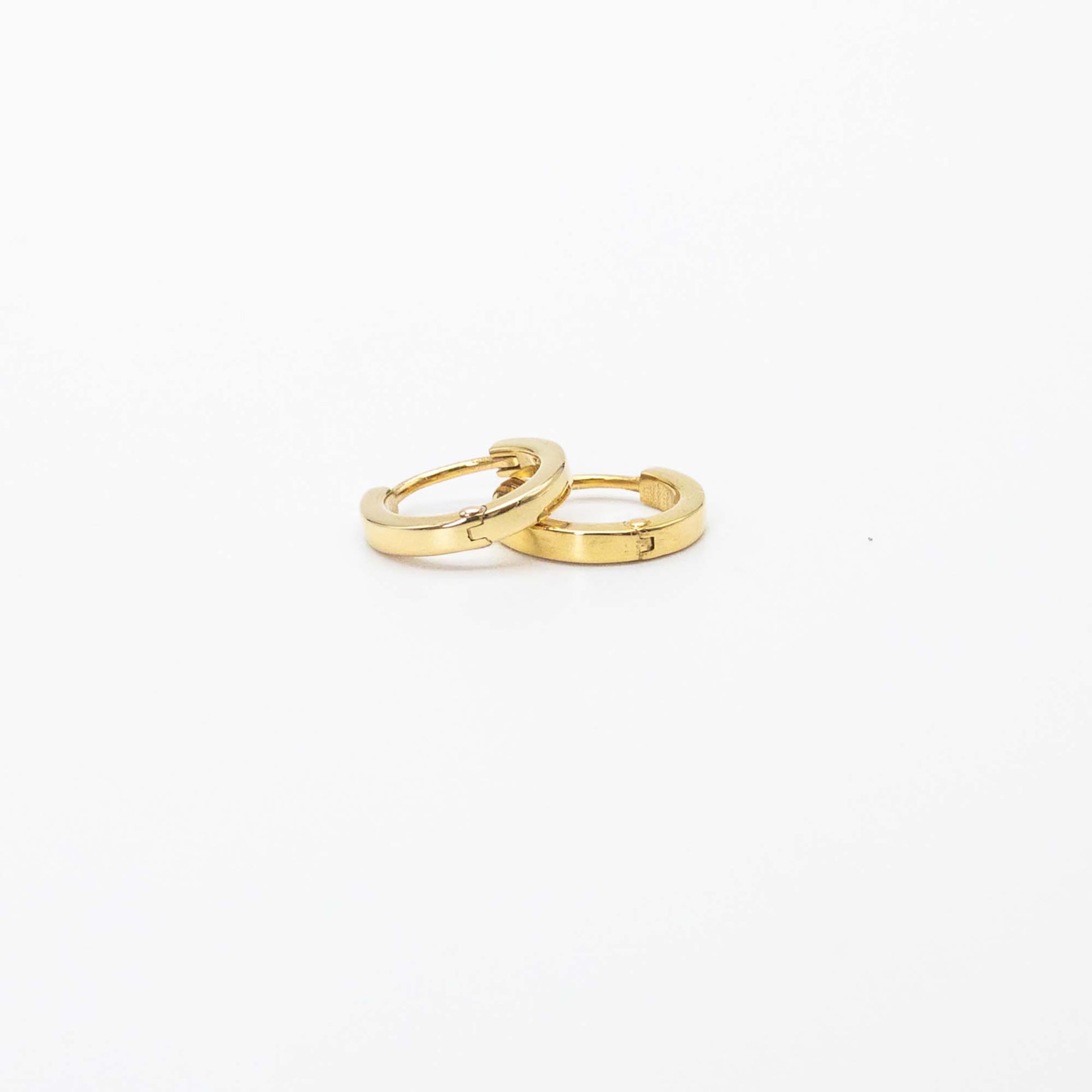 Single pair of mini gold huggies photographed on white background