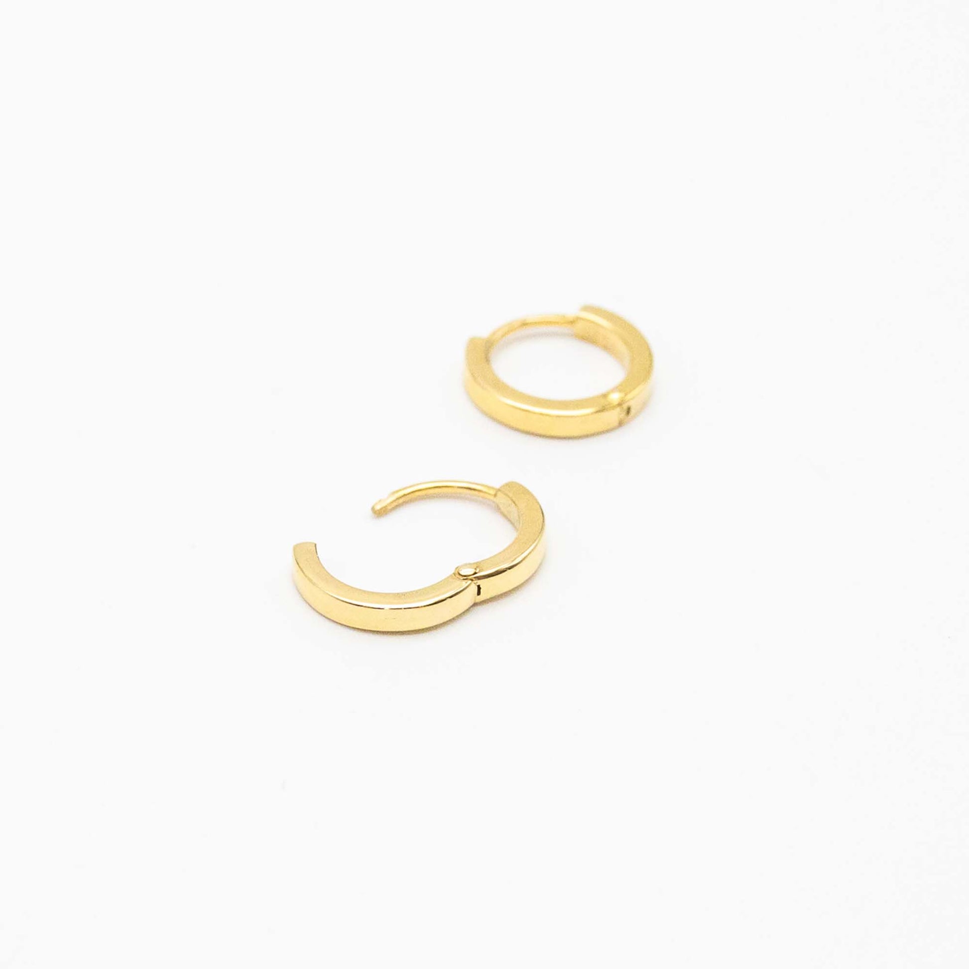 Single pair of mini gold huggies photographed on white background