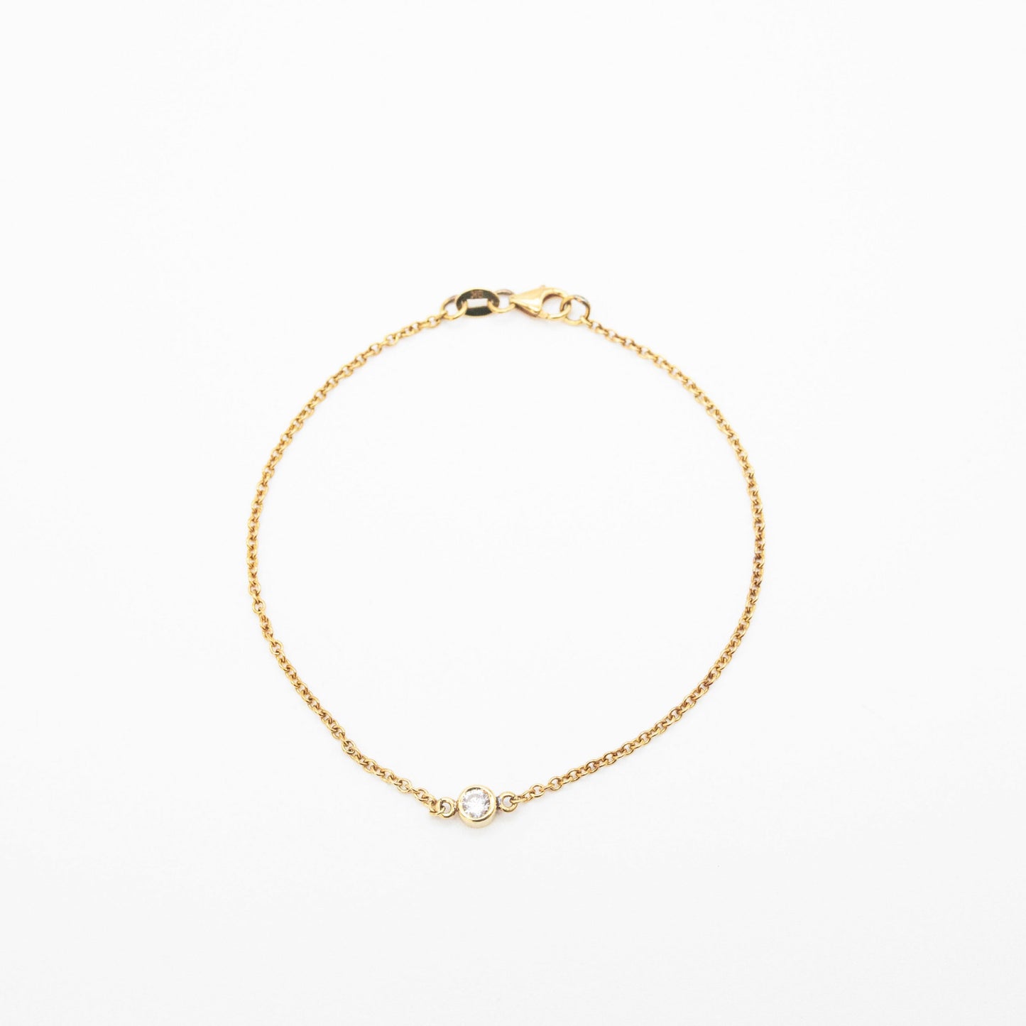 Minimalist gold bracelet featuring a single solitaire diamond, handcrafted by Leesha Fine Jewellery
