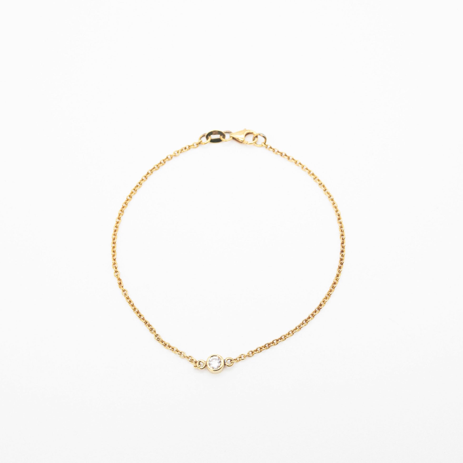 Minimalist gold bracelet featuring a single solitaire diamond, handcrafted by Leesha Fine Jewellery