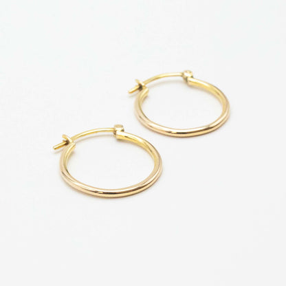 Close-up of 9ct gold small hoops highlighting polished shine and V-clip closure.