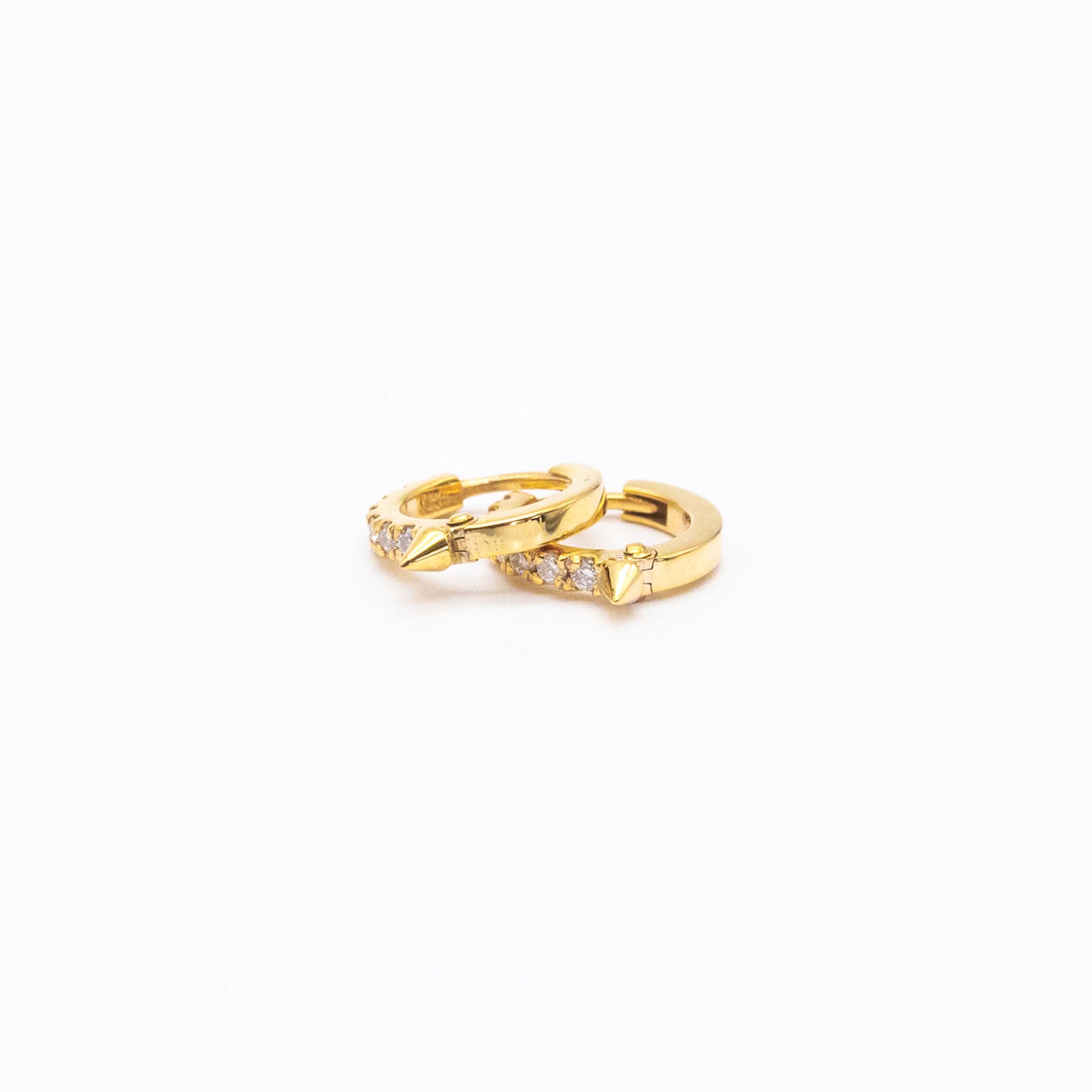 Pair of 9ct gold Spike Diamond Huggie earrings displayed on white background, showcasing front-facing diamonds.