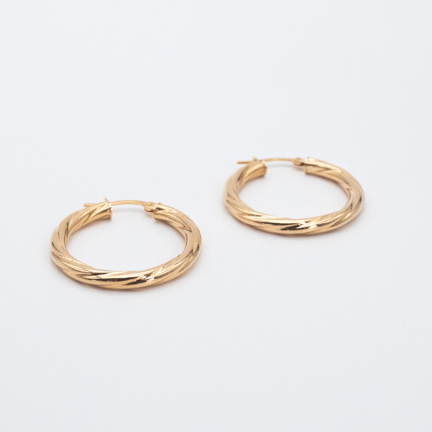 Textured 9ct gold hoop earrings featuring a 2mm twisted tube design.