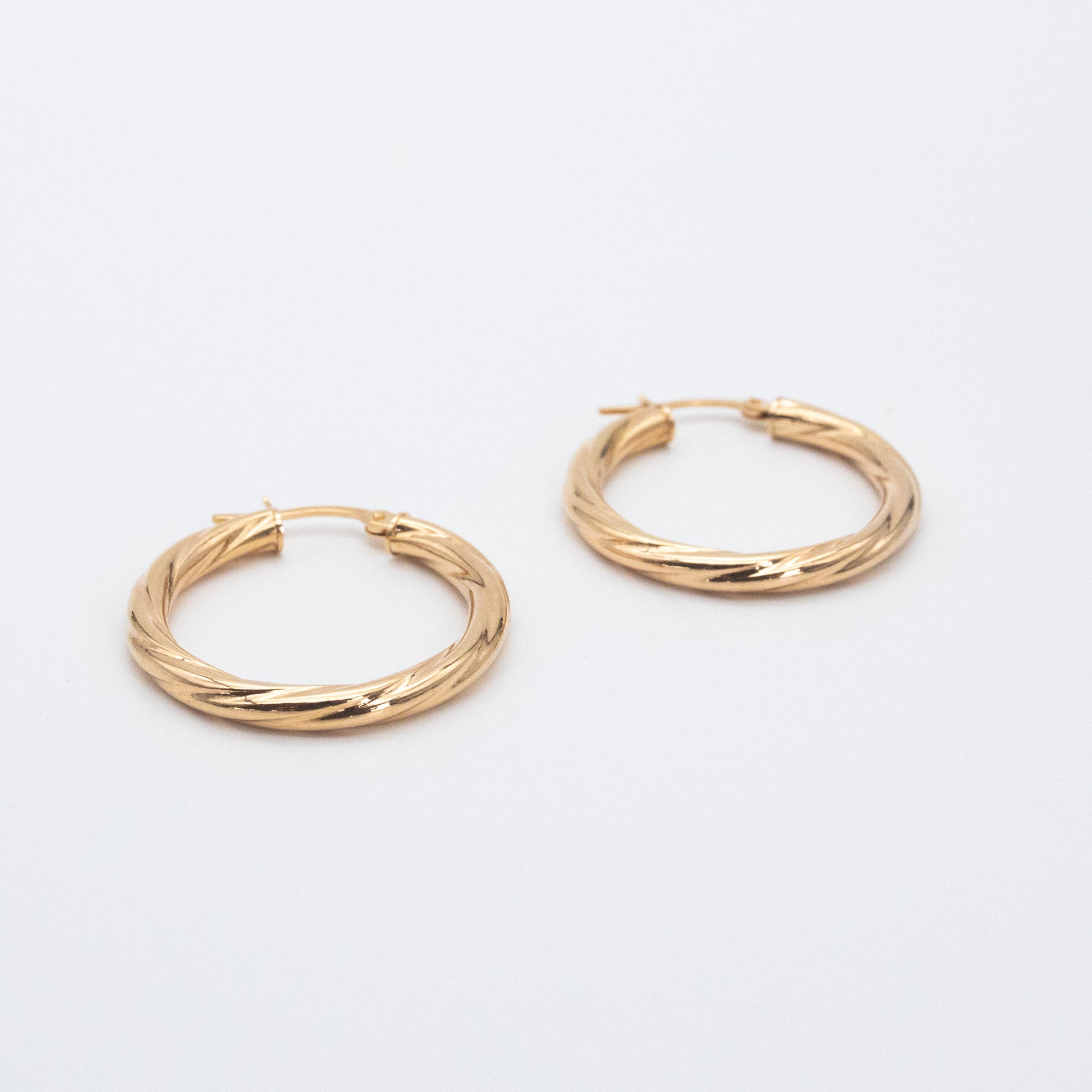 Textured 9ct gold hoop earrings featuring a 2mm twisted tube design.