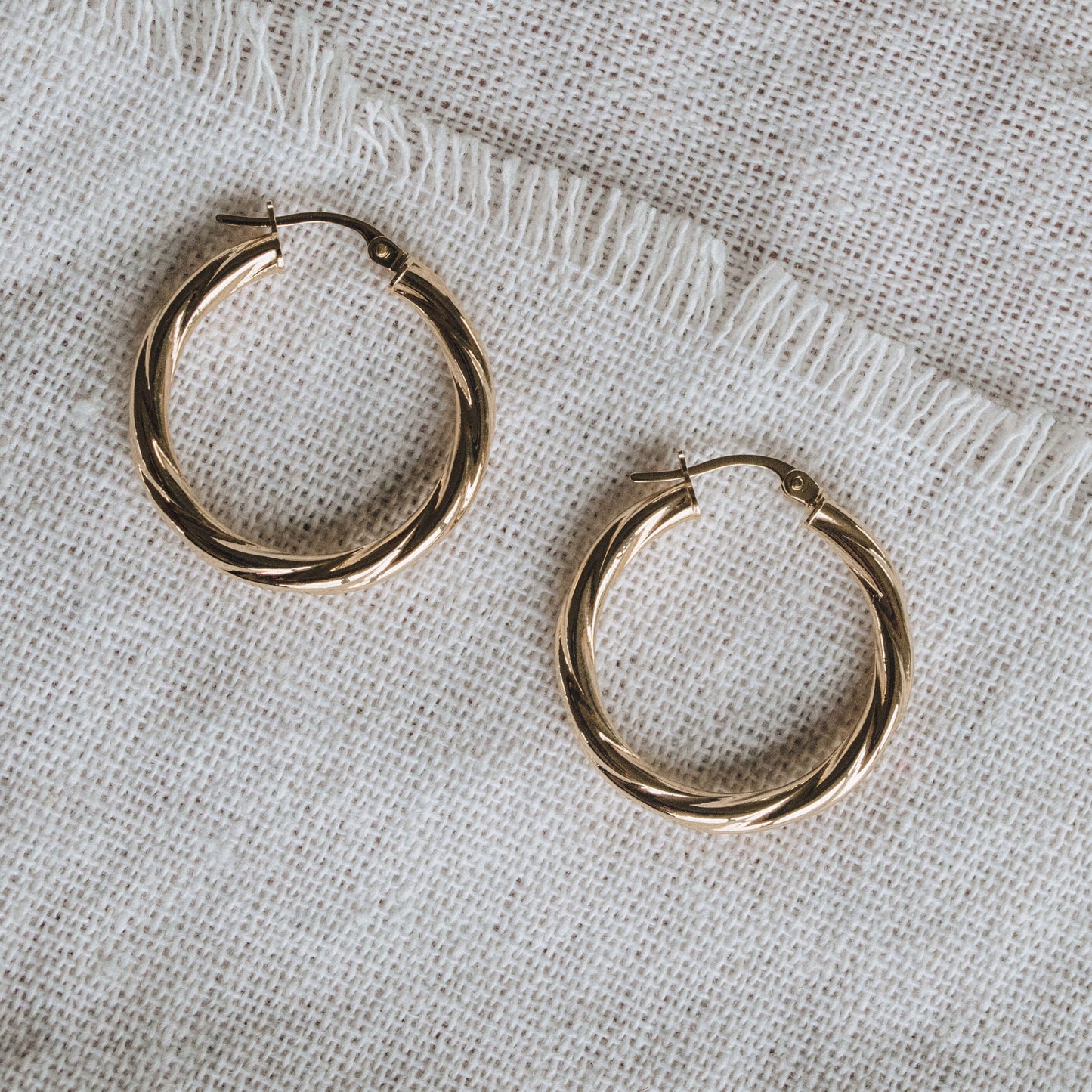 Textured 9ct gold hoop earrings featuring a 2mm twisted tube design.