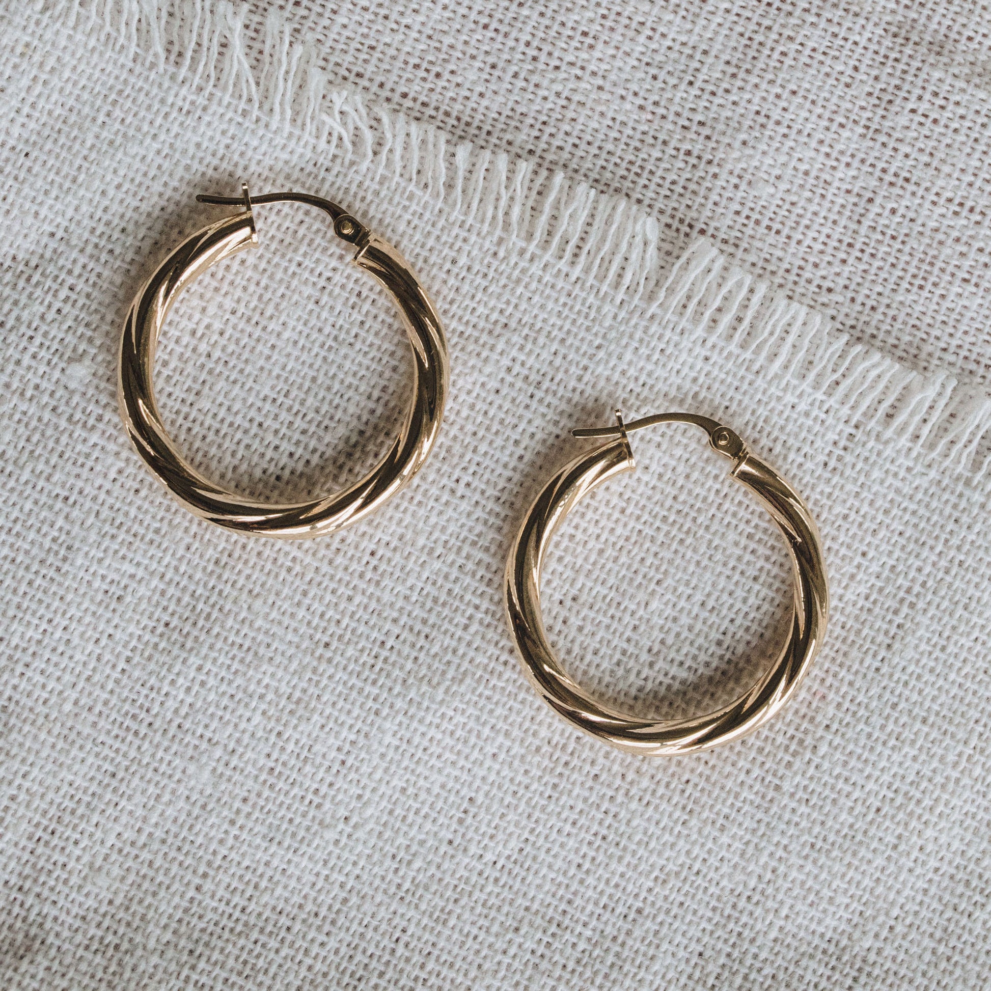 Textured 9ct gold hoop earrings featuring a 2mm twisted tube design.
