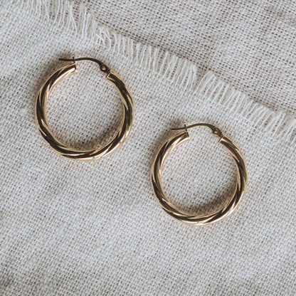 Textured 9ct gold hoop earrings featuring a 2mm twisted tube design.