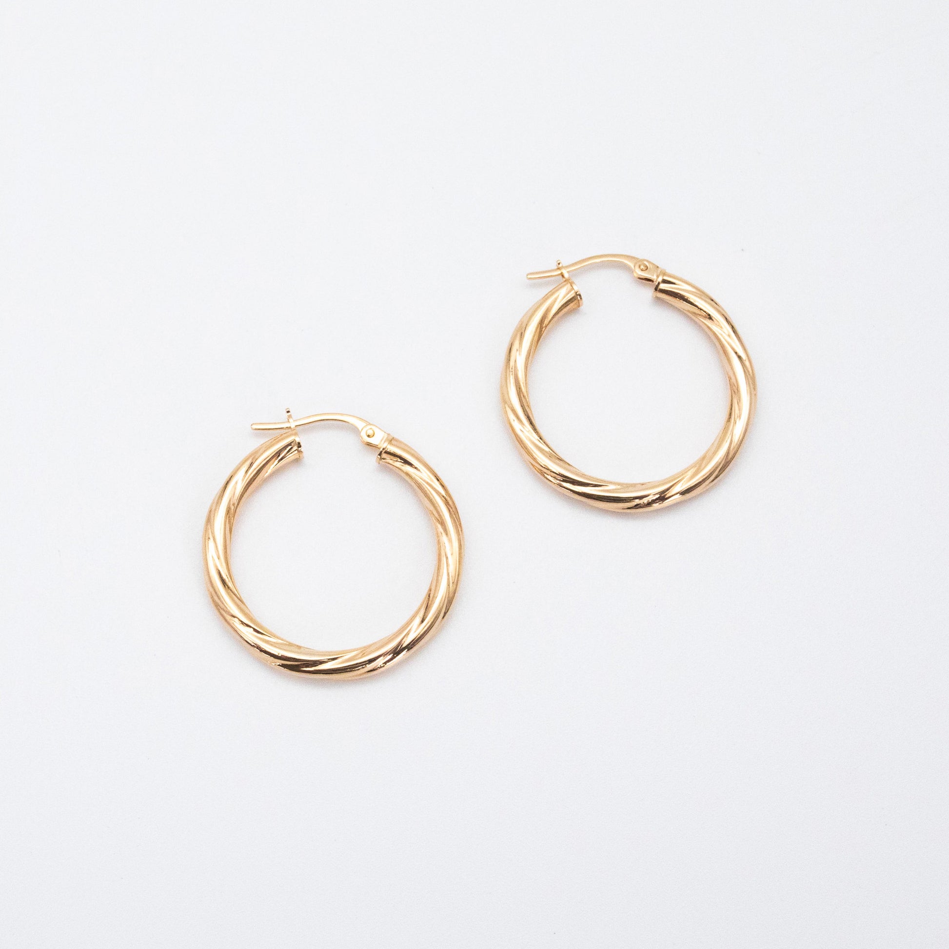 Textured 9ct gold hoop earrings featuring a 2mm twisted tube design.