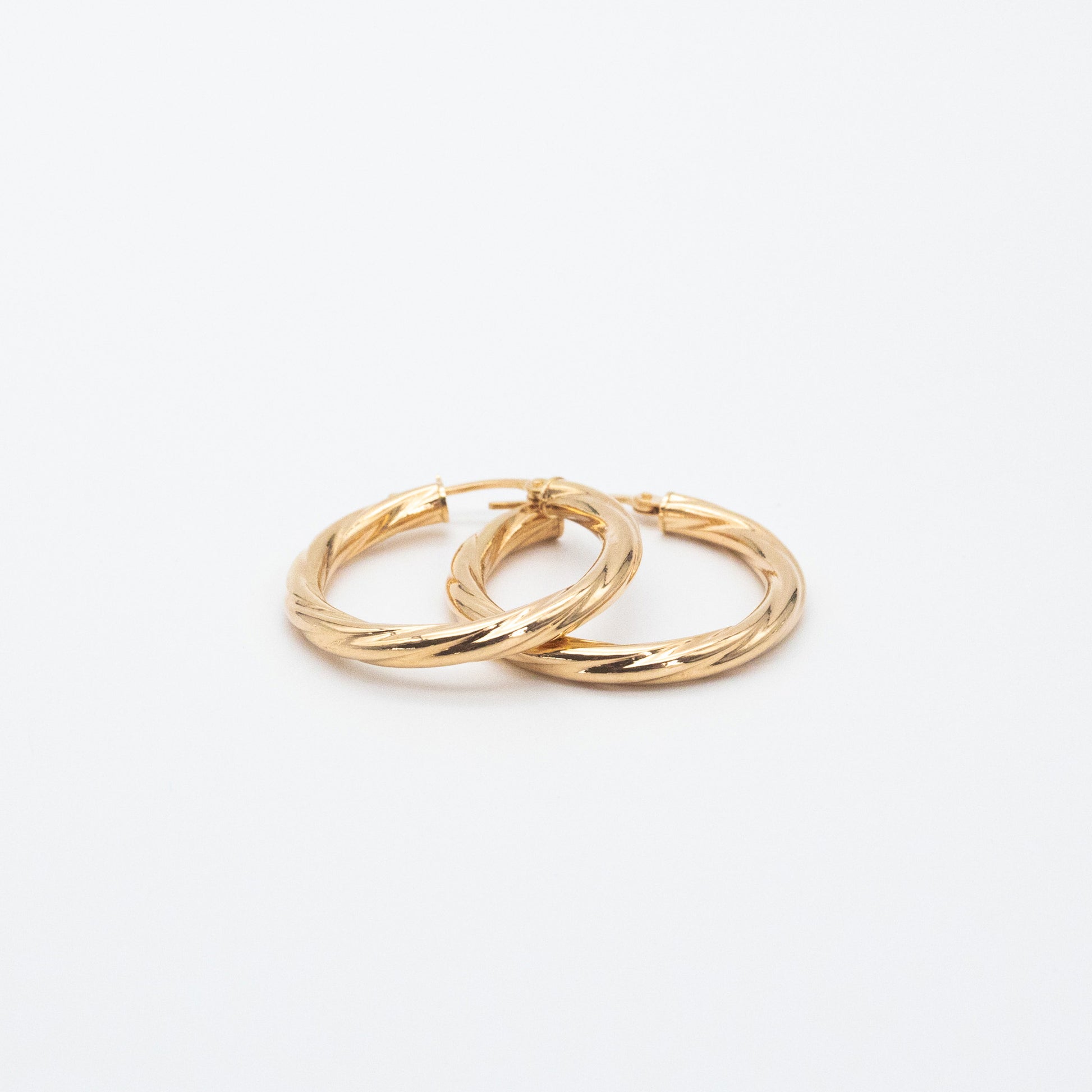 Textured 9ct gold hoop earrings featuring a 2mm twisted tube design.