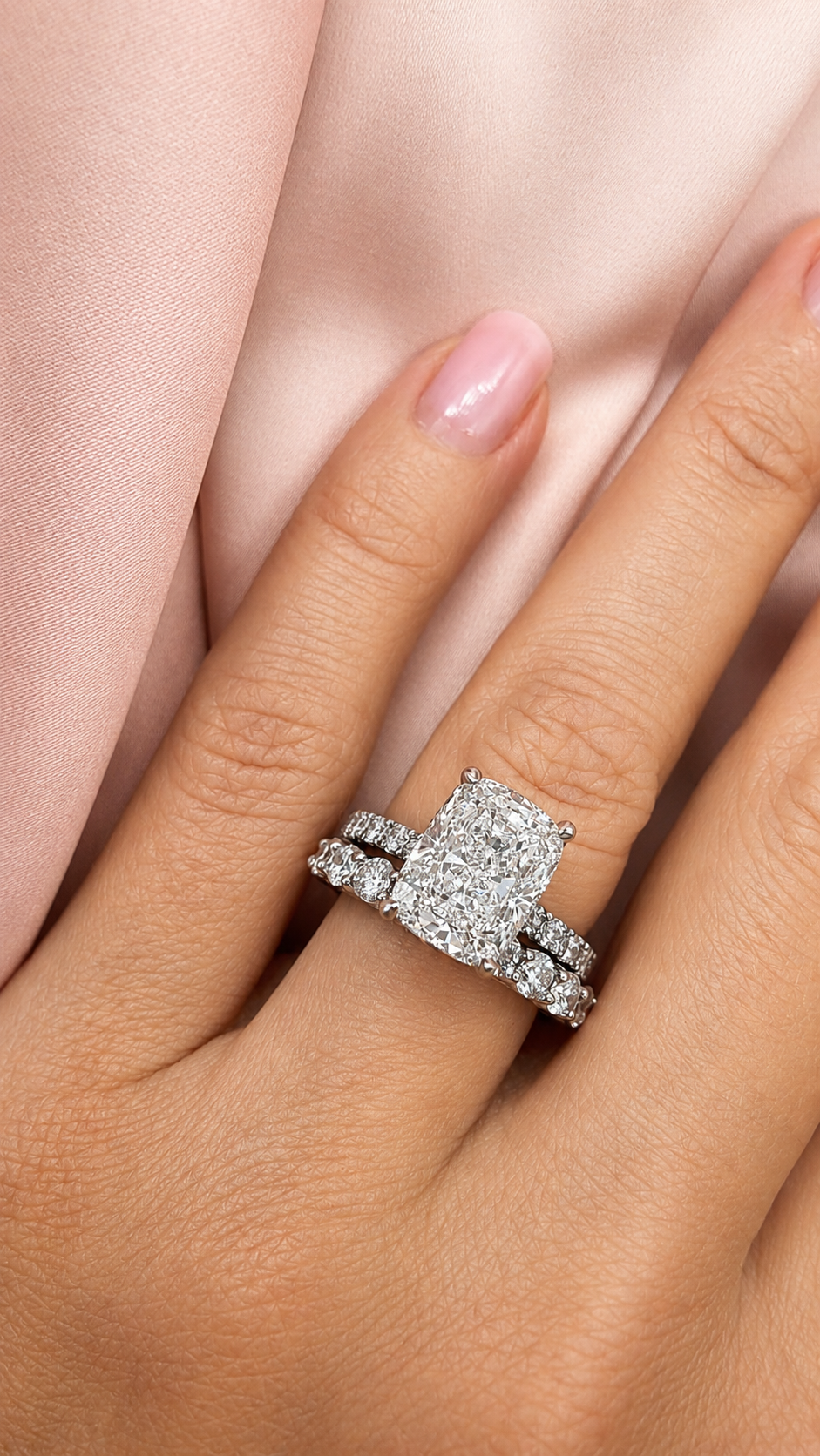 Cushion-cut diamond engagement ring with diamond wedding band on hand