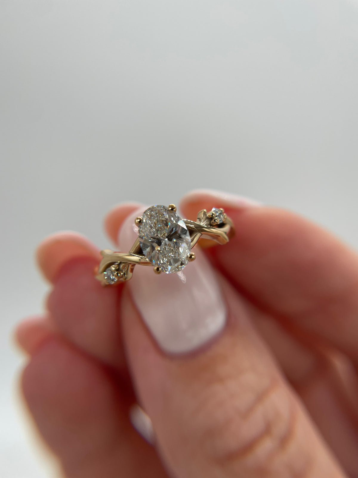 Oval diamond barbed wire engagement ring in yellow gold
