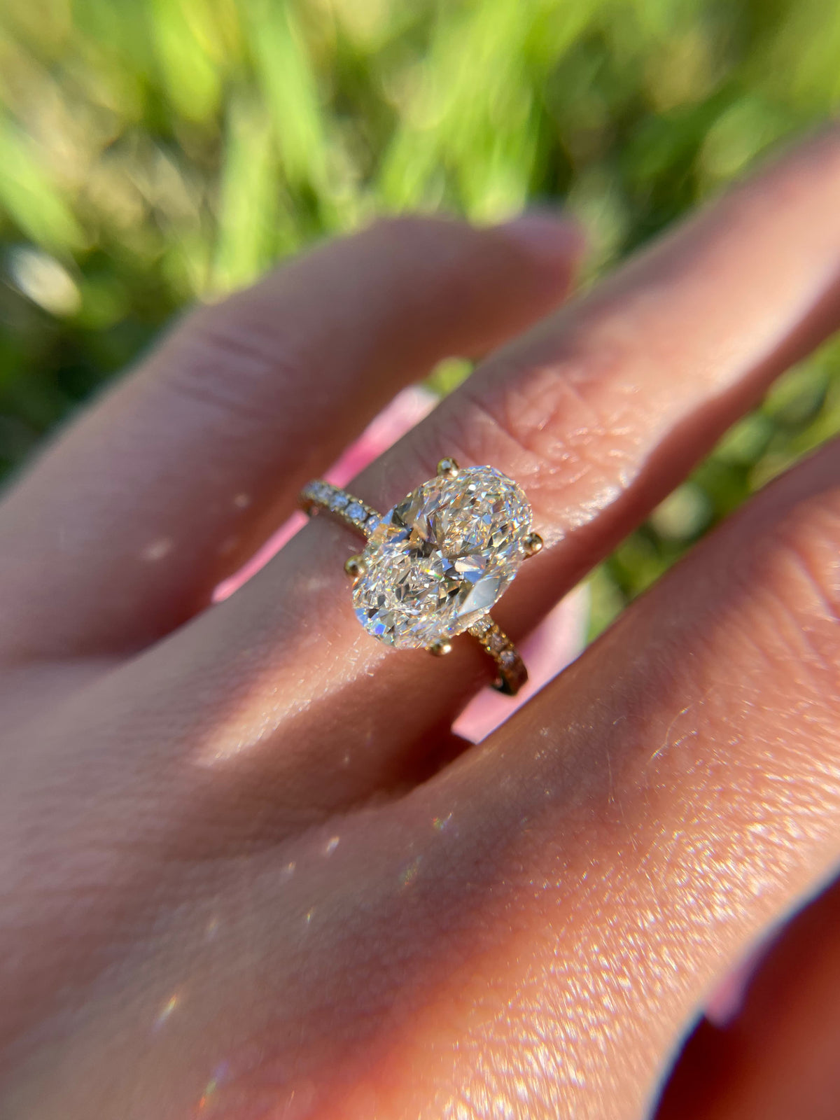 Oval diamond engagement ring with diamond-set band in yellow gold