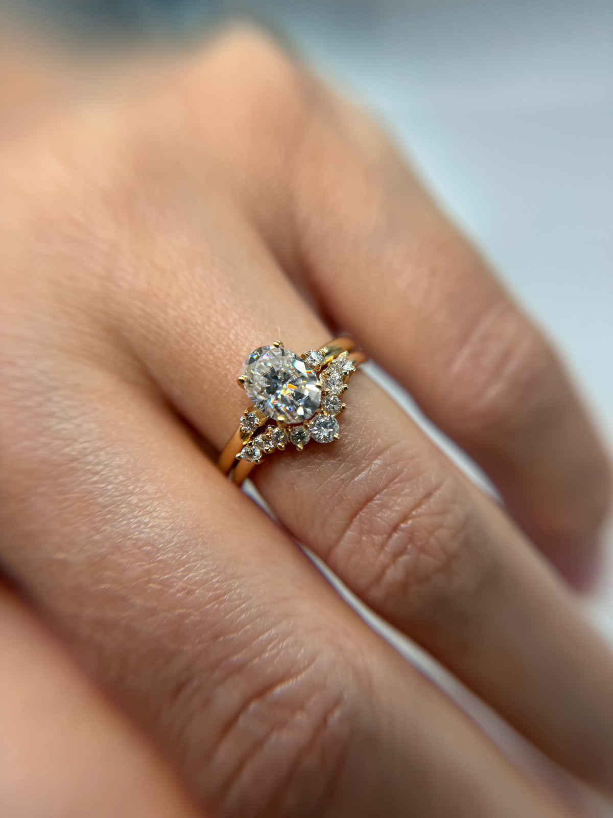 Oval diamond engagement ring with separate diamond wedding band in yellow gold