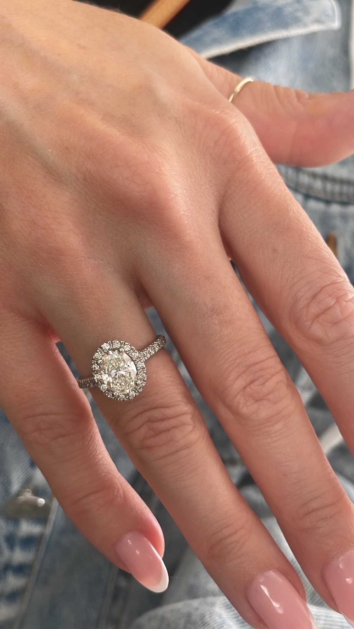 Oval diamond halo engagement ring with diamond band in platinum