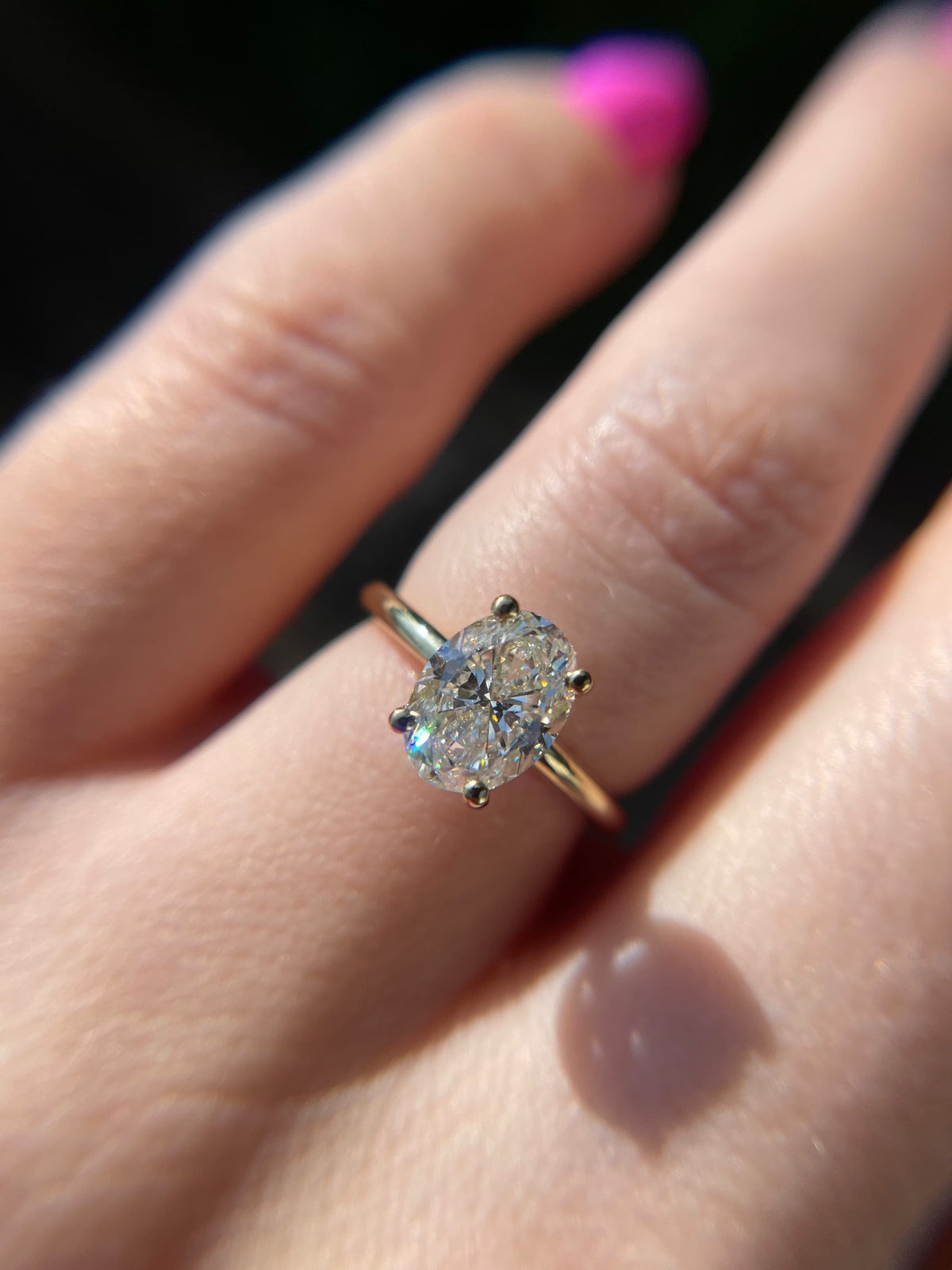 Oval diamond solitaire ring in 9ct yellow gold worn on hand