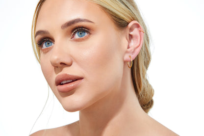 Close-up of 9ct gold small hoops highlighting polished shine and V-clip closure.