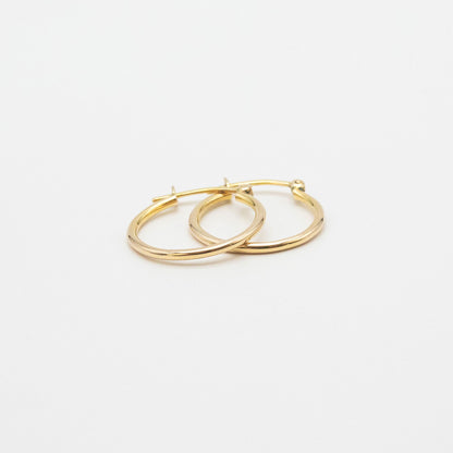 Close-up of 9ct gold small hoops highlighting polished shine and V-clip closure.