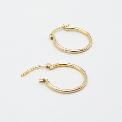 Close-up of 9ct gold small hoops highlighting polished shine and V-clip closure.